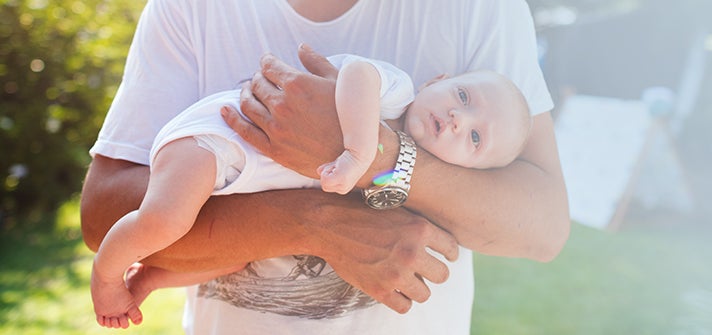 Baby being cradled in parents arms during tummy time
