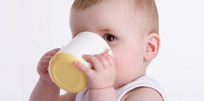 baby drinking out of an open cup