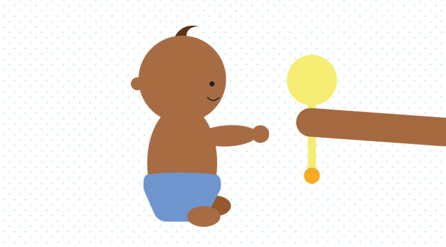 Baby being handed a rattle to reach out and grab