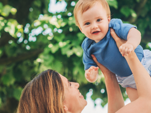 Mother holding baby in the air Infront of trees Mother holding baby in the air Infront of trees