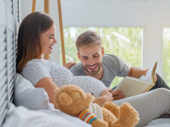 dad reading book to pregnant woman dad reading book to pregnant woman
