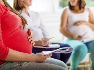 Pregnant woman in red shirt in a pre-natal class Pregnant woman in red shirt in a pre-natal class