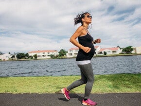 Pregnant woman exercising next to a river 