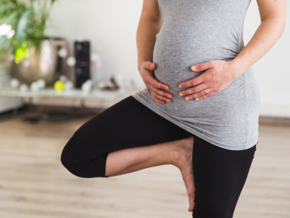 pregnant woman doing a yoga stand holding her belly pregnant woman doing a yoga stand holding her belly