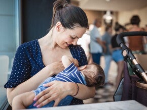 Mother breastfeeding her baby in a public place Mother breastfeeding her baby in a public place