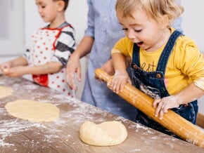 toddlers rolling out dough in the kitchen to cook toddlers rolling out dough in the kitchen to cook