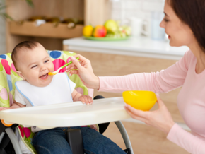 mother feeding baby with spoon mother feeding baby with spoon
