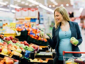 Pregnant woman selecting fresh apples. Pregnant woman selecting fresh apples.