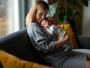 Mother holding her baby on the lounge cuddling