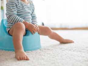 Toddler Constipation toddler in striped bodysuit sitting on blue potty