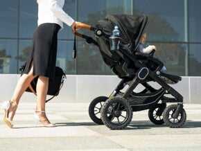 mother in business attire walking to work with her baby in a pram mother in business attire walking to work with her baby in a pram
