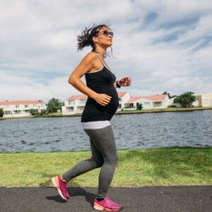 Pregnant woman exercising next to a river 