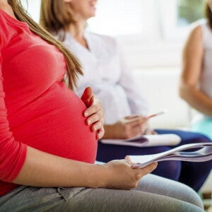 Pregnant woman in red shirt in a pre-natal class