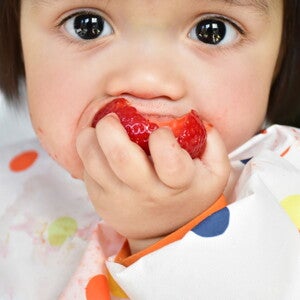 Baby eating whole strawberry baby-led weaning