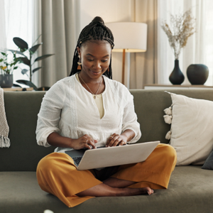 Woman in white shirt using her laptop on the couch