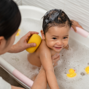 Toddler in a bubble bath with mother holding their body
