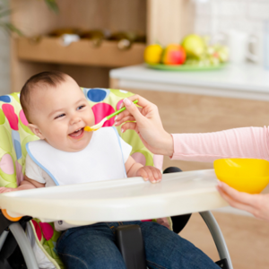 mother feeding baby with spoon