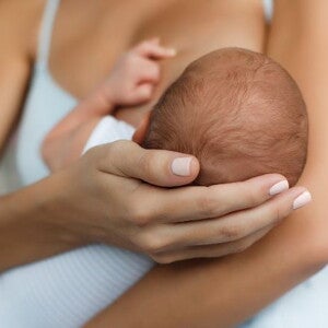 Woman holding small baby whilst breastfeeding