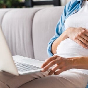 pregnant woman with laptop on her lap pregnant woman with laptop on her lap