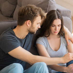 Male hugging female while sitting on the floor