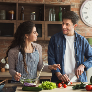 woman and man in the kitchen cutting up healthy food