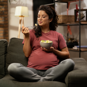 Woman sitting on the lounge eating fruit from a bowl