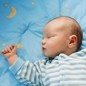 Young baby sleeping on a blanket with moon and stars