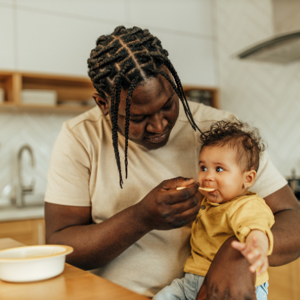 Father feeding their child solids