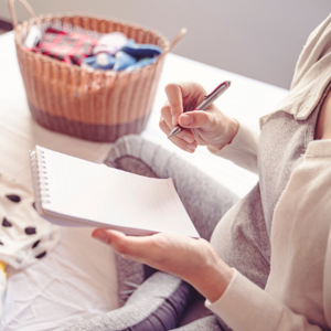 Pregnant woman writing on a notepad