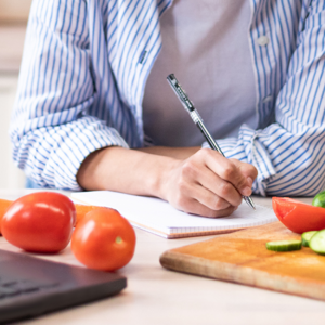 writing down a menu in the kitchen with food around writing down a menu in the kitchen with food around