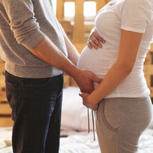 Pregnant woman and her partner holding her belly
