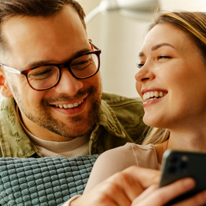 Couple looking at their mobile smiling Couple looking at their mobile smiling
