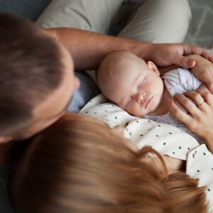 two parents holding their young baby
