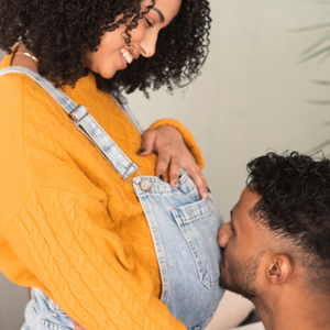 Man kissing pregnant womans stomach Man kissing pregnant womans stomach