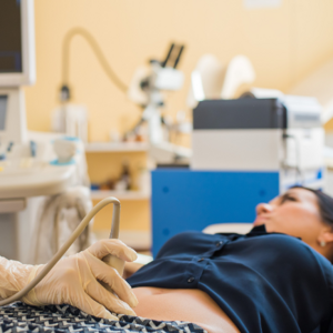 woman laying on doctors bed and doctor assessing her stomach