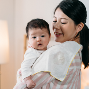 mother holding her baby with towel on her shoulder
