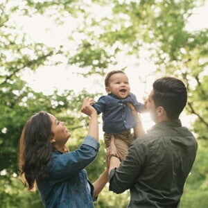 mother and father holding toddler in the air mother and father holding toddler in the air