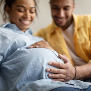 Pregnant woman and her partner holding her pregnant belly