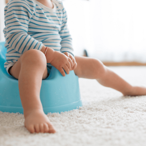 toddler in striped bodysuit sitting on blue potty