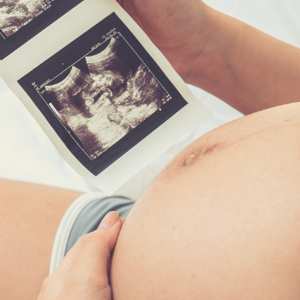 Pregnant woman holding a baby scan image Pregnant woman holding a baby scan image