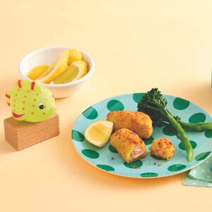 Cripsy salmon nuggets on a green spotted plate with yellow background