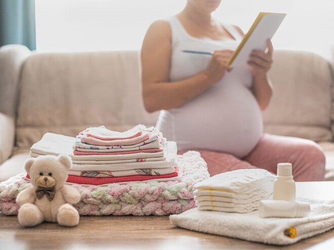 Pregnant woman packing with a list Pregnant woman packing with a list