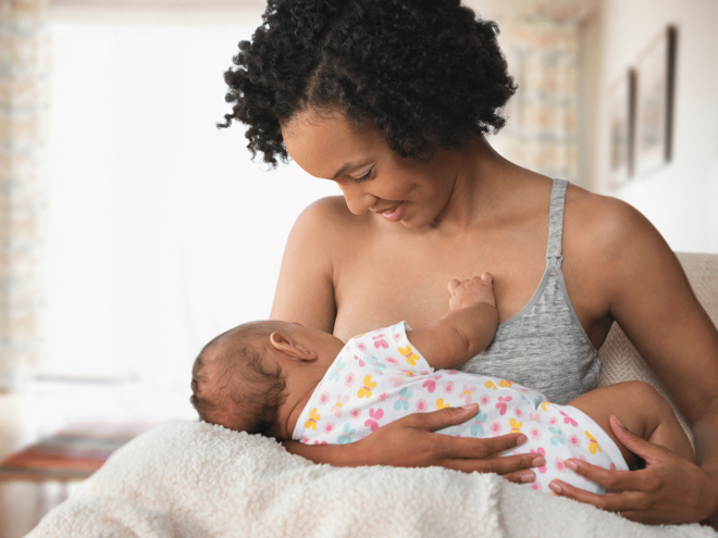 Mother breastfeeding her baby while smiling Mother breastfeeding her baby while smiling