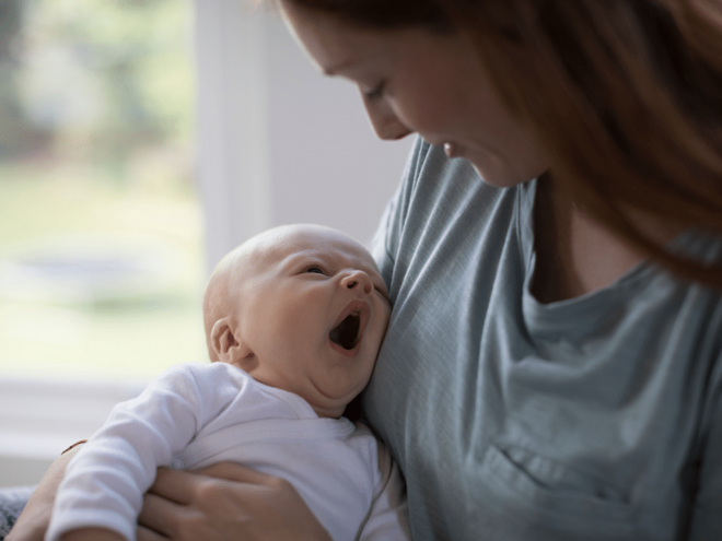 Baby tired yawning in mothers arms Baby tired yawning in mothers arms