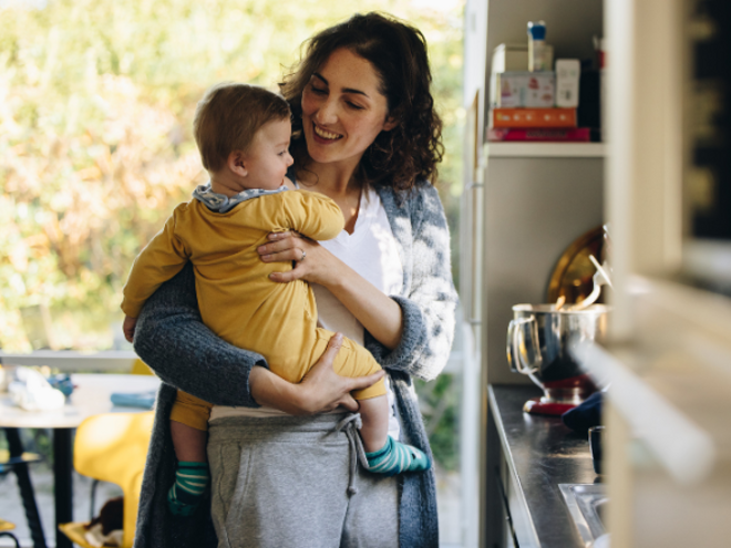 Mother holding baby in arms in a kitchen Mother holding baby in arms in a kitchen