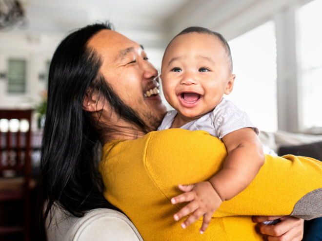 Asian dad holding young laughing baby Asian dad holding young laughing baby