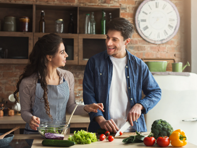 woman and man in the kitchen cutting up healthy food woman and man in the kitchen cutting up healthy food