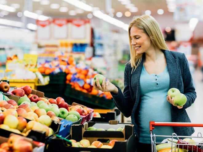 Pregnant woman selecting fresh apples. Pregnant woman selecting fresh apples.