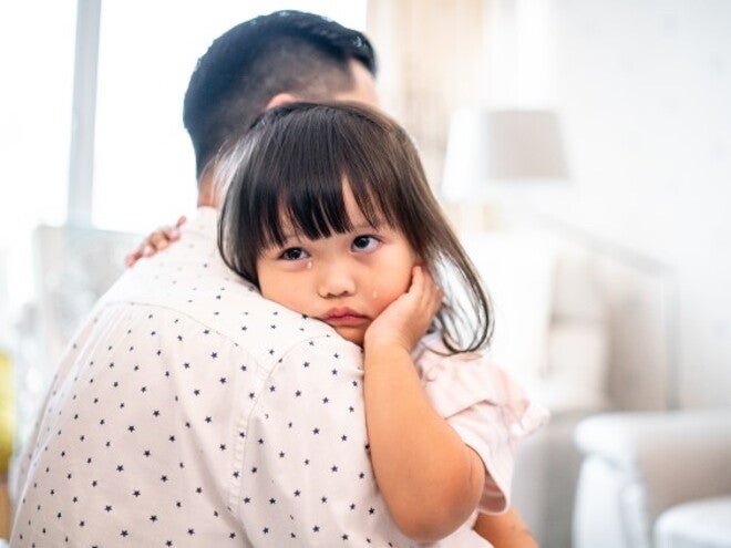 Toddler crying on her dads shoulder Toddler crying on her dads shoulder