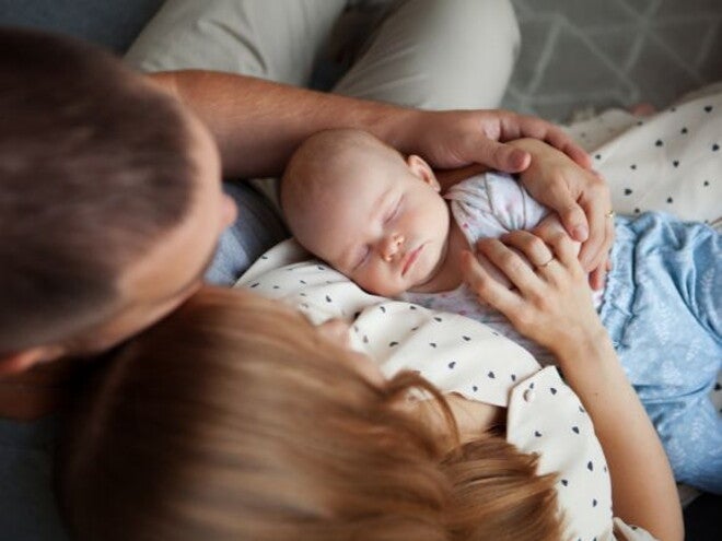 two parents holding their young baby two parents holding their young baby